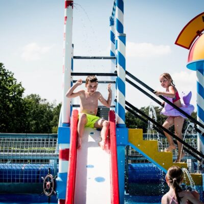 Het kinderzwembad heeft een speeltoestel met glijbaan